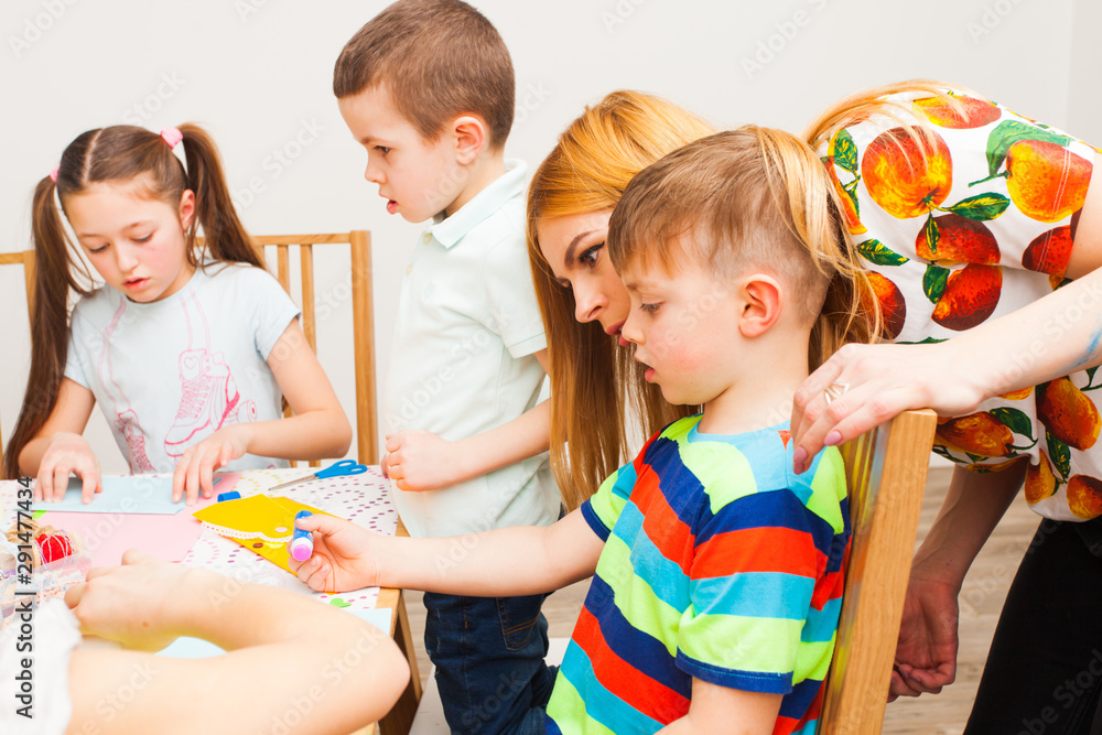 Fototapeta premium Mother helps his son to make postcard