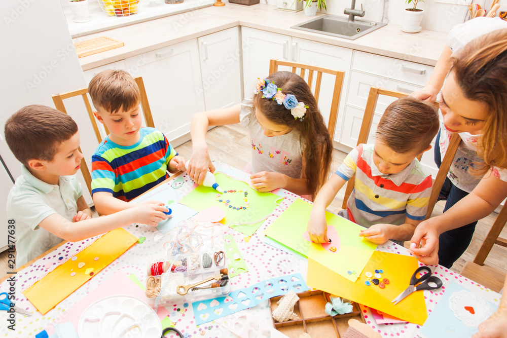 Naklejka premium Cute little children attend masterclass on how to do postcards