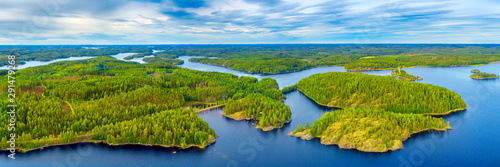 Aerial view of of small islands on a blue lake Saimaa. Landscape with drone. Blue lakes, islands and green forests from above on a cloudy summer morning. Lake landscape in Finland.