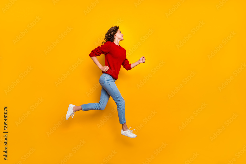 Full length photo of funny lady jumping high rushing shopping wear knitted pullover isolated yellow background Full length photo of funny lady jumping high rushing shopping wear knitted pullover isolated yellow background