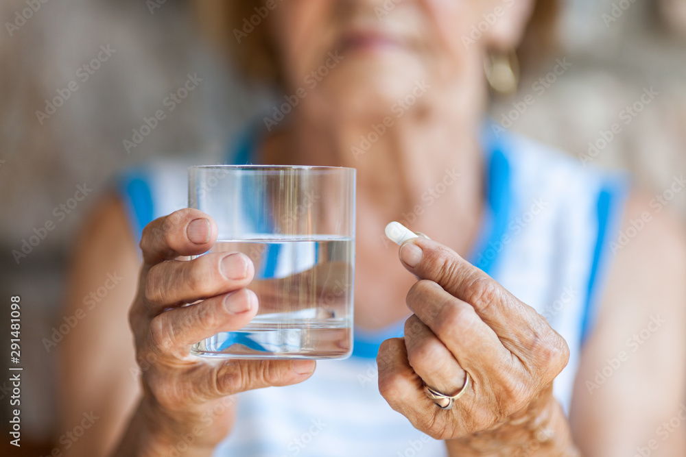 Senior woman taking her daily medication Senior woman taking her daily medication