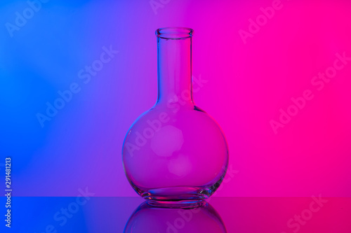 Chemical glassware close up on neon pink-purple background