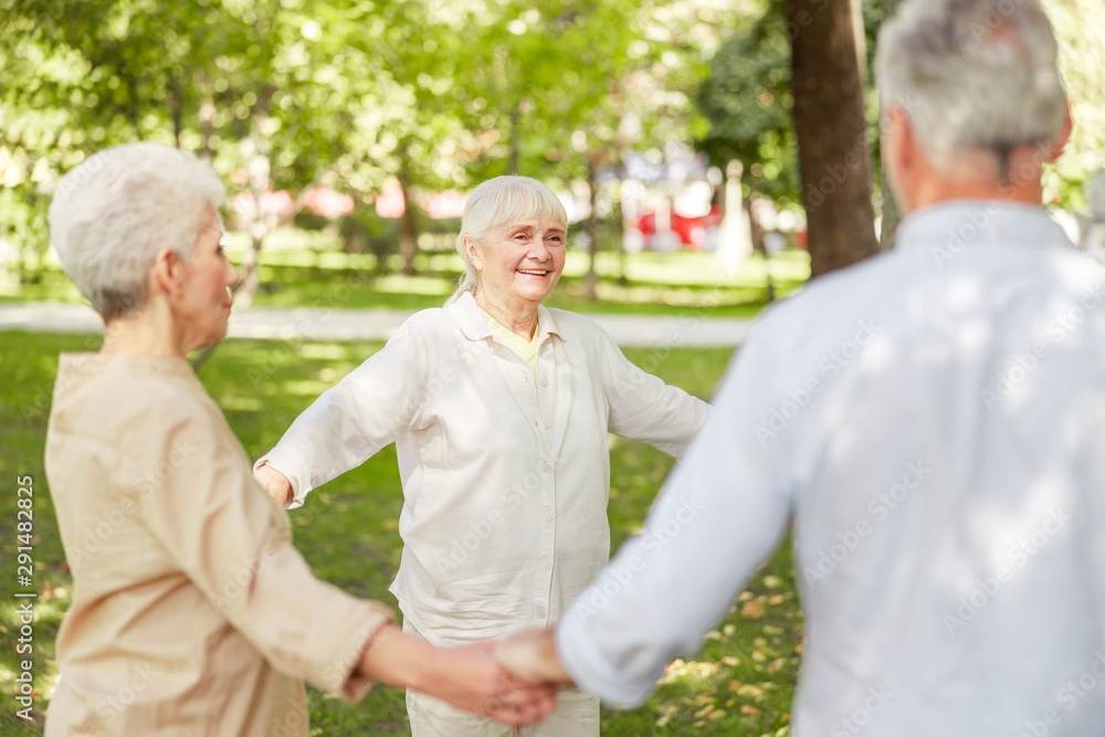 Joyful elderly people practicing chi kung in the park Joyful elderly people practicing chi kung in the park