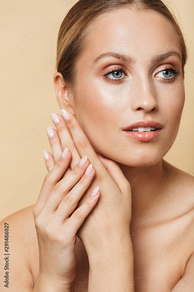 Woman posing naked isolated over beige wall background. Woman posing naked isolated over beige wall background.