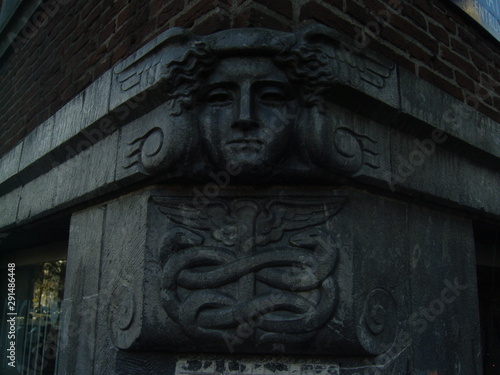 Stone head on corner of building with snake symbol