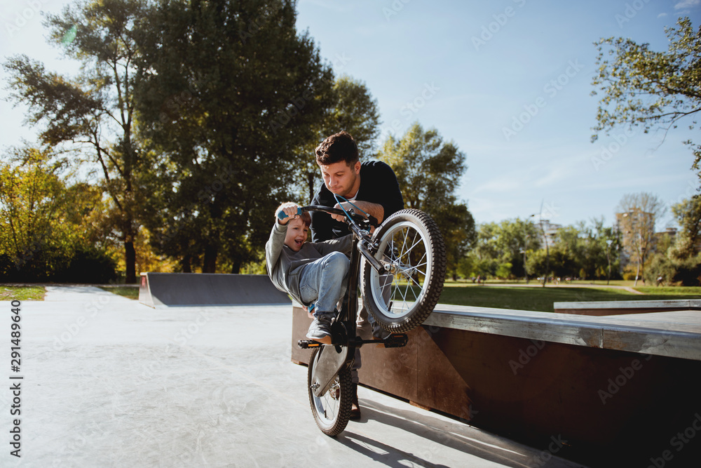 Obraz premium Father Learning his son to ride a bicycle