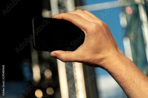 Hand holding a smartphone with a black screen and takes a close-up of what is happening