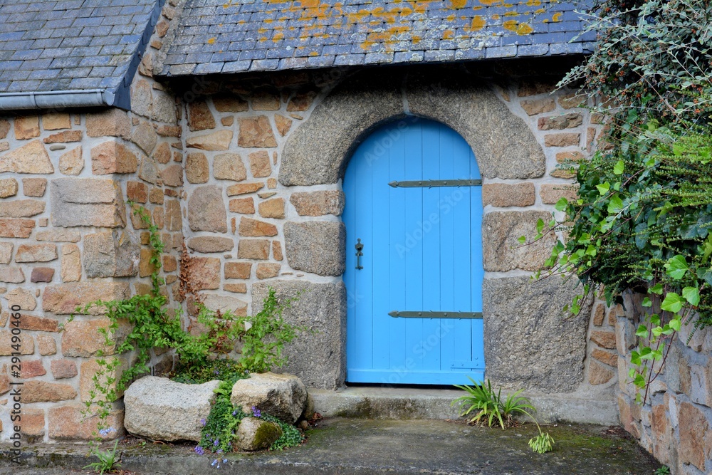 Porte en bois bleue dans un mur en granit rose en Bretagne, France Porte en bois bleue dans un mur en granit rose en Bretagne, France