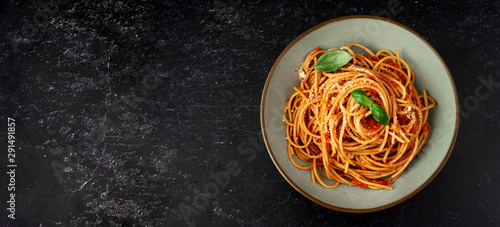 Spaghetti with tomato sauce on black background