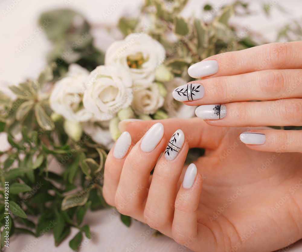 Gentle neat manicure on female hands on flowers background. Nail design  Stock Photo | Adobe Stock