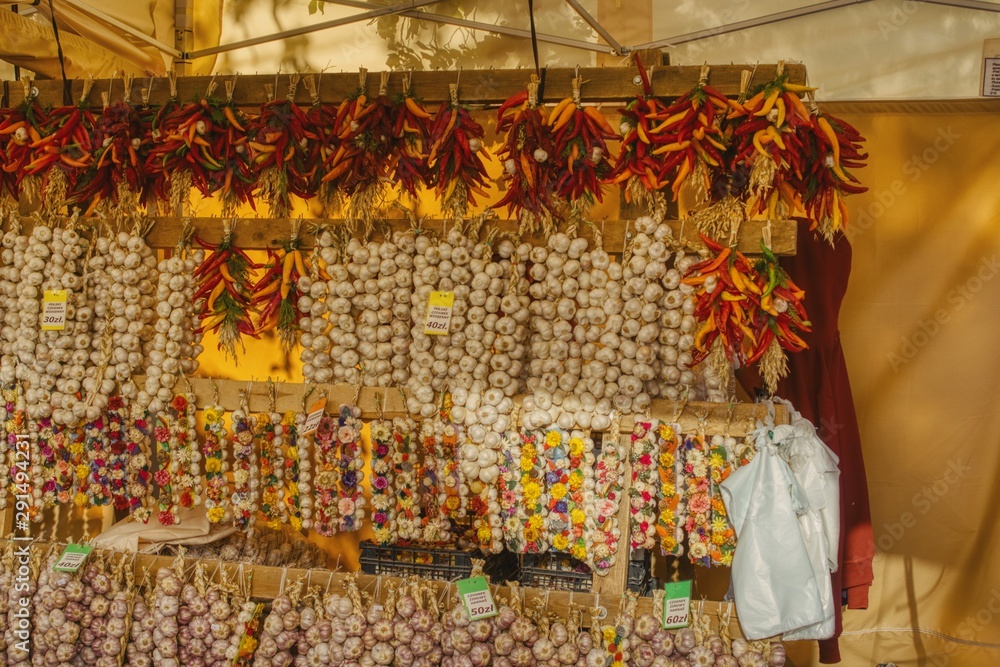 sale of spices during street trade on the occasion of St. Francis fair, decorative garlands of garlic, dried colorful varieties of pepper