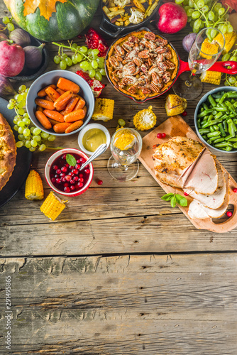 Thanksgiving family dinner setting concept. Traditional Thanksgiving day food  with turkey, green beans and mashed potatoes, stuffing, pumpkin, apple and pecan pies, rustic wooden table