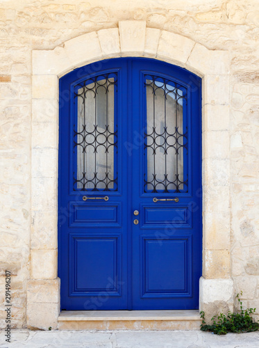 Beautiful old door in dark blue. Fragment of the facade of a Sandstone house, Cyprus, Europe.