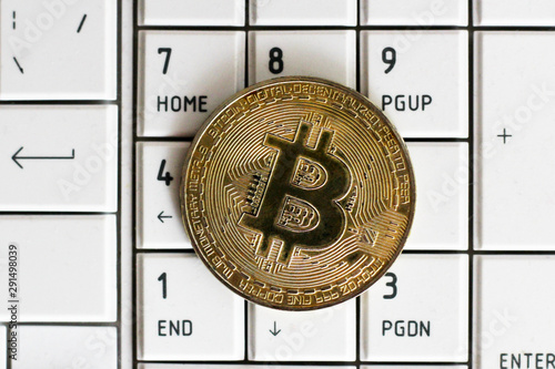 Photo Golden Bitcoins on notebook keyboard. Crypto currency concept. Top view.