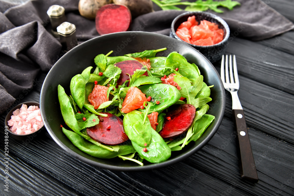 Plate with tasty salad on dark table Plate with tasty salad on dark table