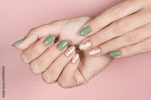 Closeup top view of beautiful female hands isolated on pink background. Woman with beautiful trendy stylish two colours pastel manicure. Horizontal color photography.