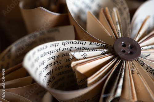 Stylish origami-type hand-made folded paper flowers constructed from buttons and pages from an old book