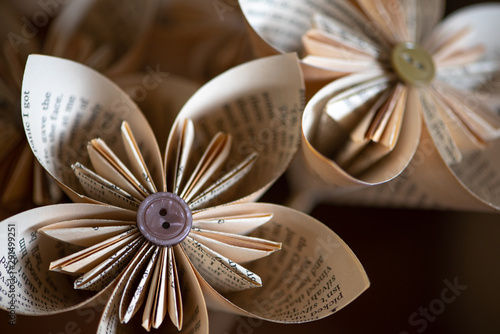 Stylish origami-type hand-made folded paper flowers constructed from buttons and pages from an old book