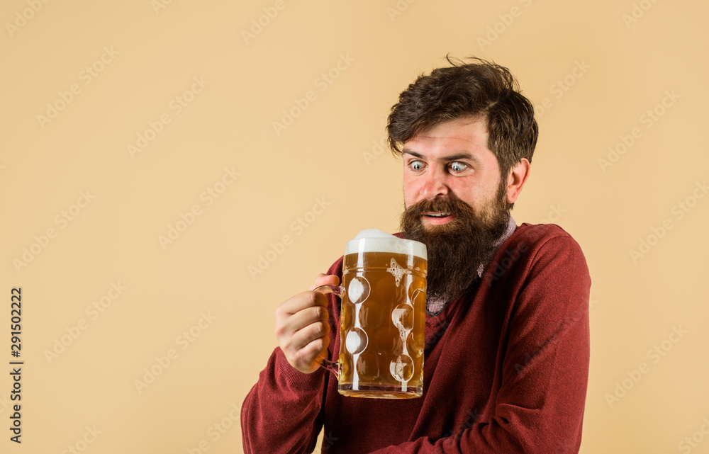 Bearded man holds beer glass. Handsome man drinks ale at bar or pub. Beard man drinking beer from mug. Young man tasting draft beer. Beer time. Celebration oktoberfest festival. Lager and dark ale.