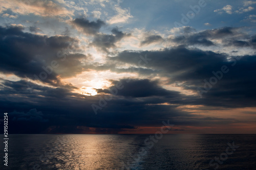 Fototapeta Naklejka Na Ścianę i Meble -  Sunrise breaking through the clouds over the ocean 