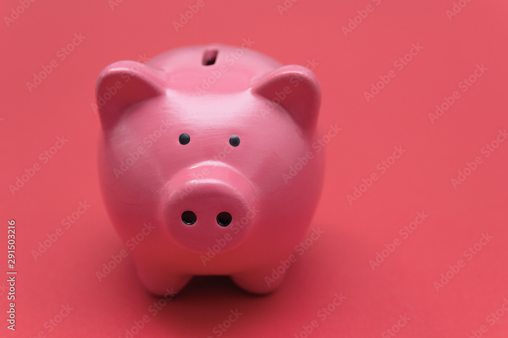 Piggy bank on a red-pink background. Free space for an inscription.