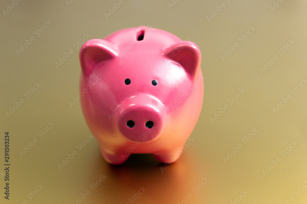 Piggy bank on a gold background. Free space for an inscription.