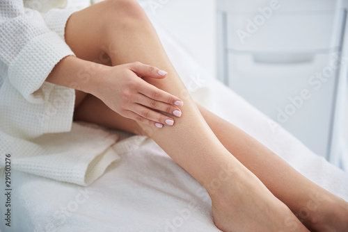 Young woman placing hand on her beautiful perfect shin