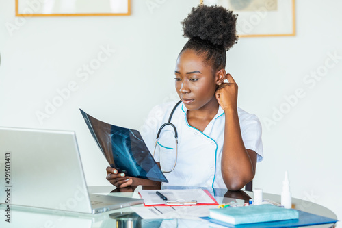 Doctor looking shoulder x-ray film in hospital. Radiography concept. radiology female doctor examining x ray film of patient at hospital room. photo