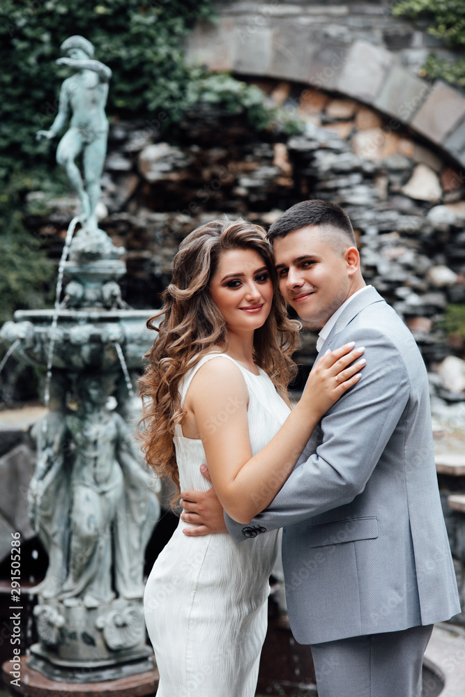 Young couple in love outdoor. Stunning sensual outdoor portrait of young stylish fashion couple posing in summer.  Handsome man and attractive young woman are in love.  Love is in the air