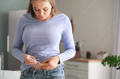 Diabetic woman giving herself insulin injection photo