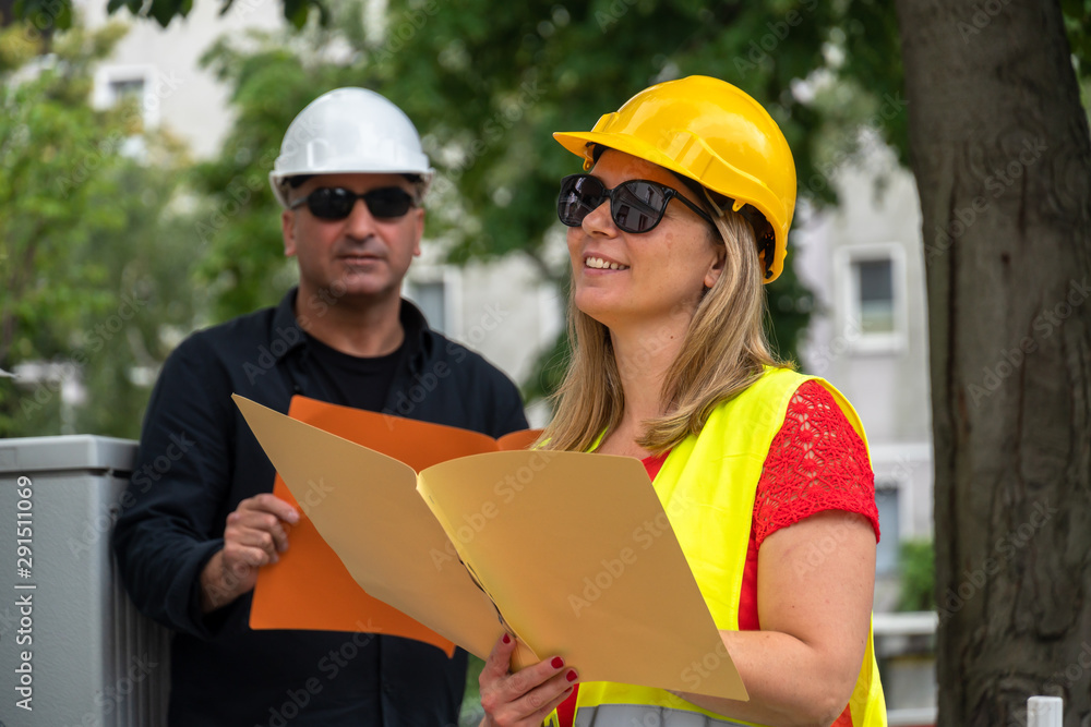 custom made wallpaper toronto digitalMale and female civil engineers checking office blueprints and projects on construction site