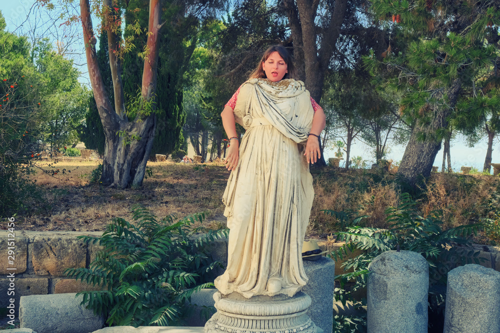 A young woman depicts a dead statue of ancient Greece or antique Rome