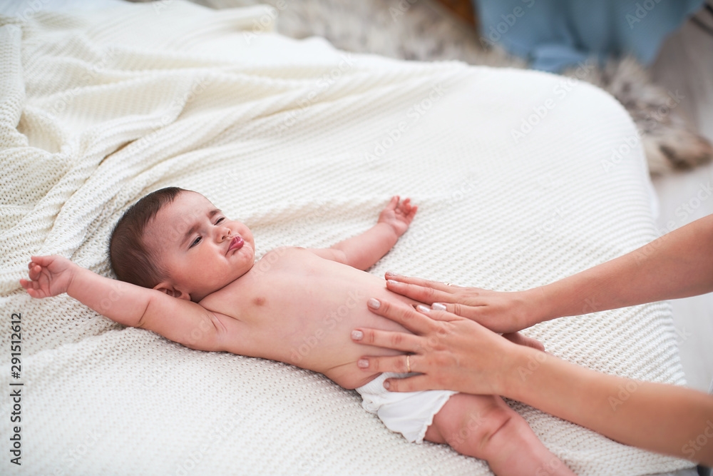 Masseur massaging the tummy of the baby during colic Masseur massaging the tummy of the baby during colic
