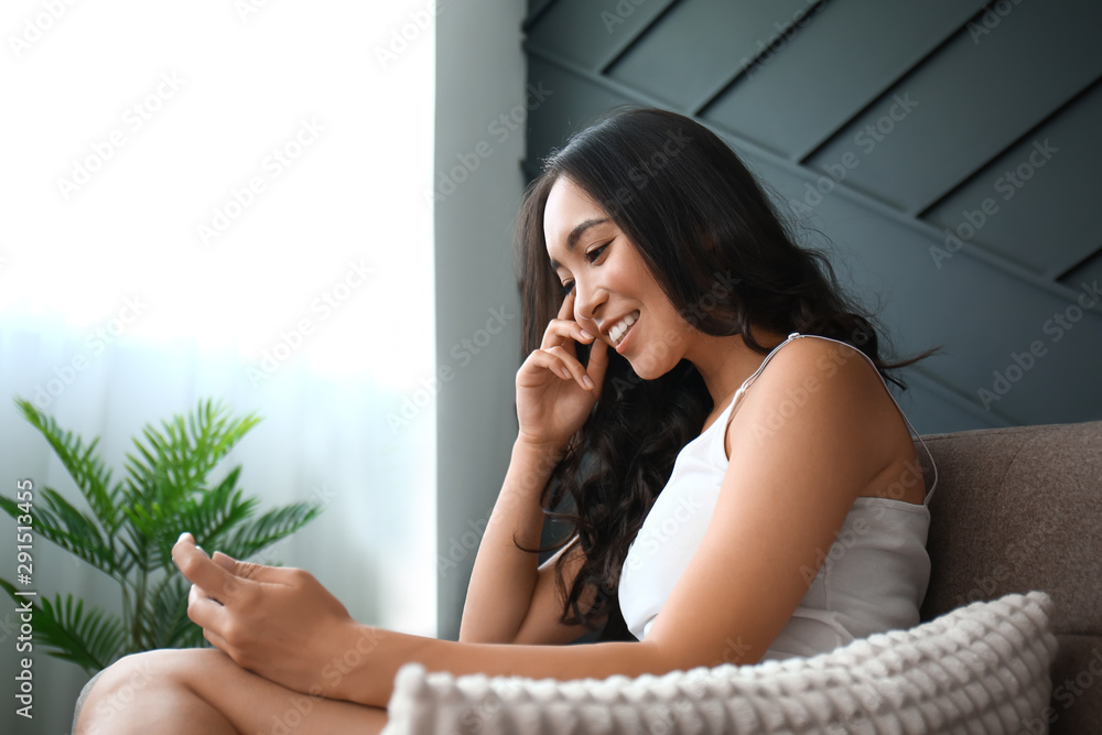 Beautiful Asian woman with mobile phone at home Beautiful Asian woman with mobile phone at home