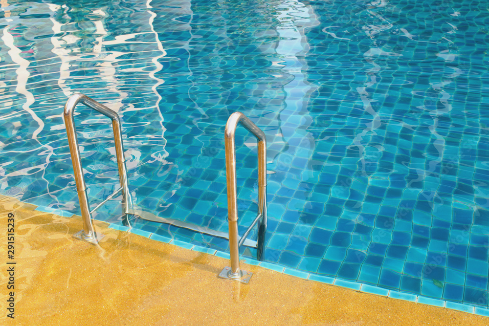 Swimming pool with grab bars ladder and stairs.