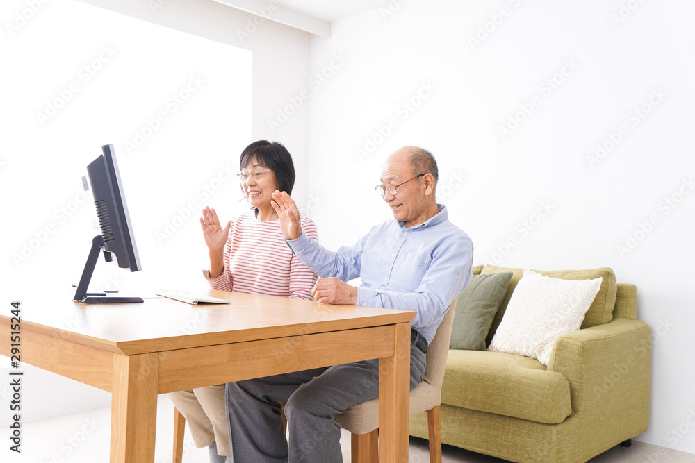 パソコンでテレビ電話をする高齢の夫婦 パソコンでテレビ電話をする高齢の夫婦