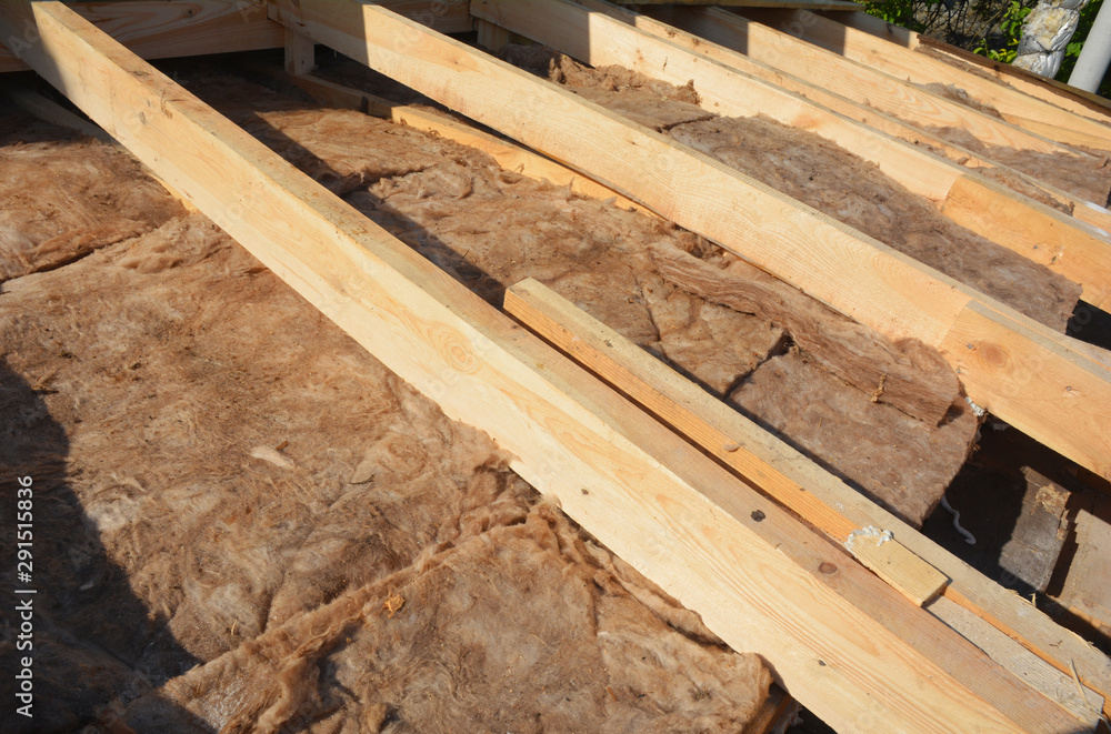 Insulating with Mineral Rock Wool Attic Roof. Close up on insulation layers of mineral wool insulation, house roof insulation Insulating with Mineral Rock Wool Attic Roof. Close up on insulation layers of mineral wool insulation, house roof insulation
