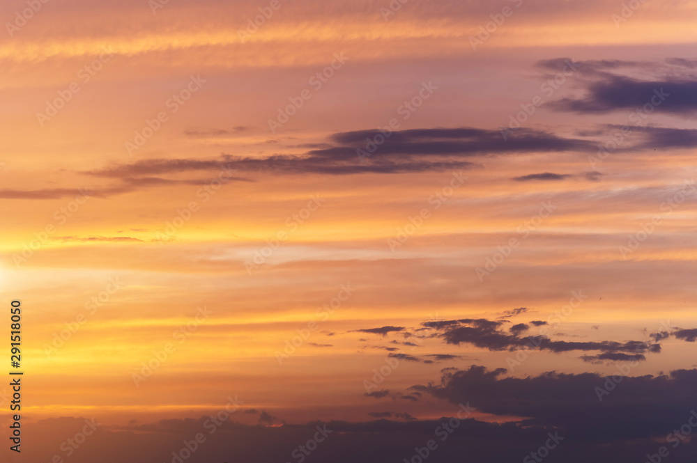 Abstract nature background. Dramatic sunset sky in the clouds saturated with bright colors of orange and yellow. Contrast Low Key