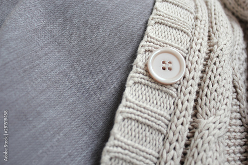 Knitted sweater with buttons and linen blouse. Autumn clothes top view. Autumn closet background. 