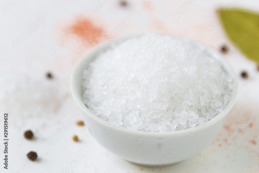 salt in white bowl and colorful spices on a white background salt in white bowl and colorful spices on a white background