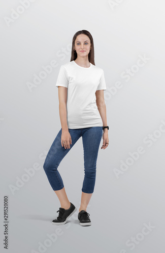 Standing beautiful female model wearing white plain crew neck t shirt in blue denim jeans capri pant. Isolated background