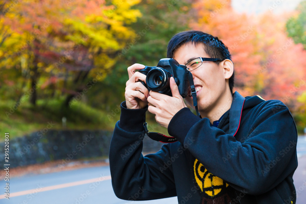 Photographer tourist man take photo of colourful tree leaves Photographer tourist man take photo of colourful tree leaves
