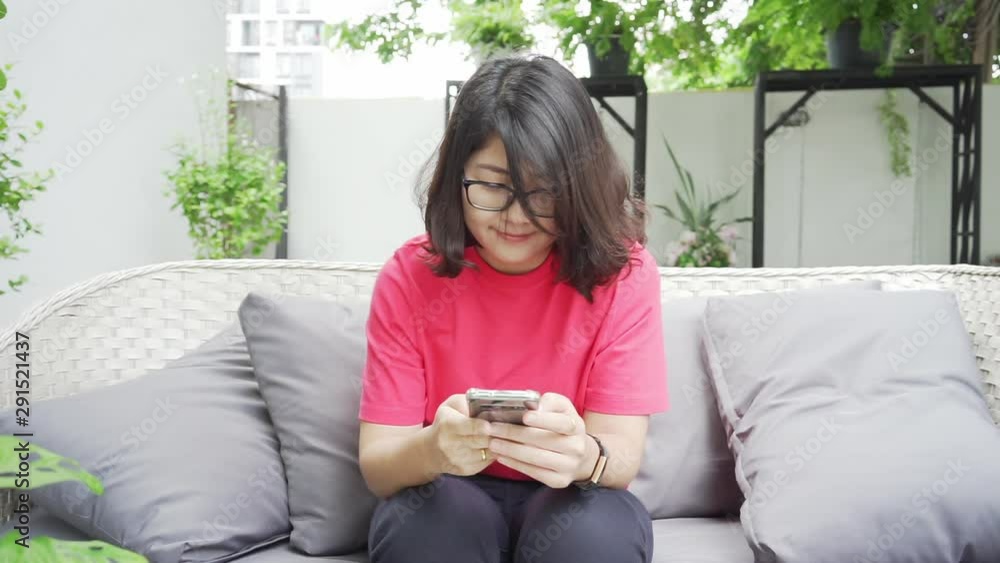 Asian woman buys online products via mobile phone And pay by credit card While sitting and resting in the house Online shopping Asian woman buys online products via mobile phone And pay by credit card While sitting and resting in the house Online shopping