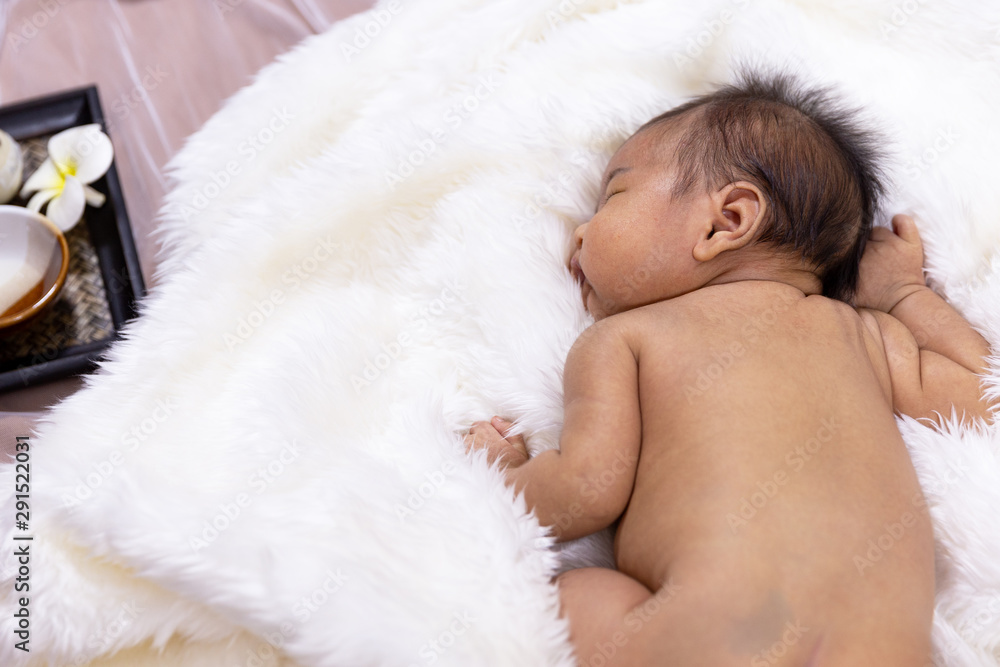 In spy massage room,Cute asian newborn baby lying on white fur towel,portrait of little child boy,five week old.