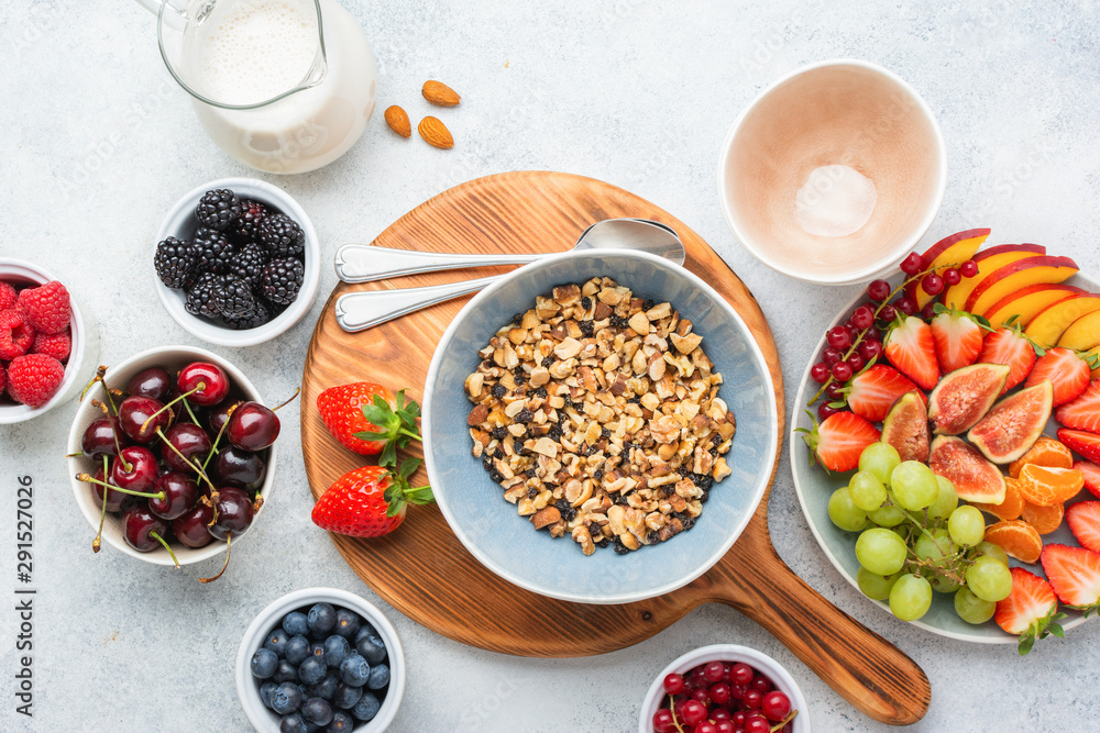 Gluten free and grain free paleo granola or muesli made from nuts. Fruit berries platter, strawberries blueberries raspberries peach figs red currant, top view, selective focus Gluten free and grain free paleo granola or muesli made from nuts. Fruit berries platter, strawberries blueberries raspberries peach figs red currant, top view, selective focus