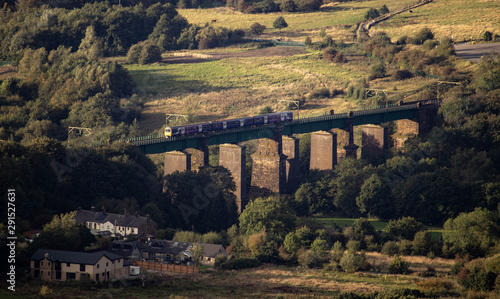 A train travelling over an old bridge in the centre of Glossop