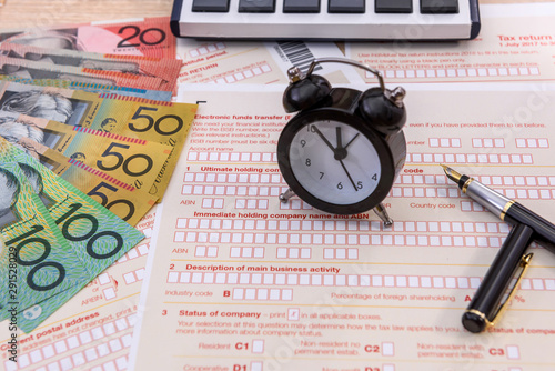 Clock and pen on australian tax form close up