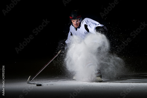 Photography ice hockey player in action kicking with stick