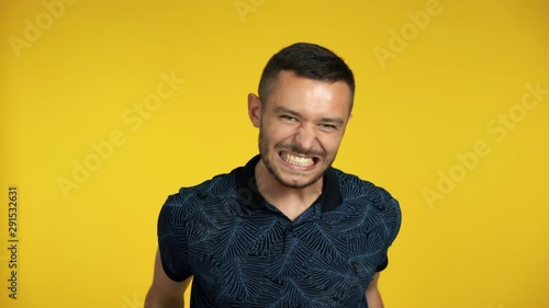 Happy excited man celebrate success isolated on yellow background
