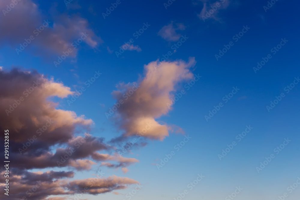 blue sky background with dark fluffy clouds